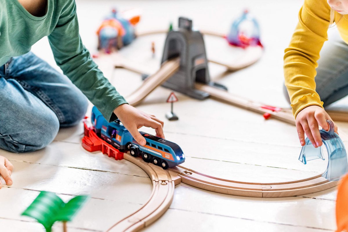 Kids plying with Brio Train on floor.