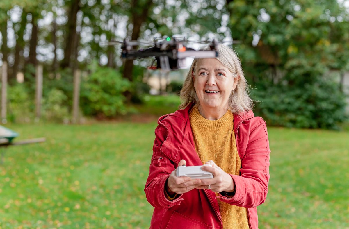 Happy lady in the garden flying drone.