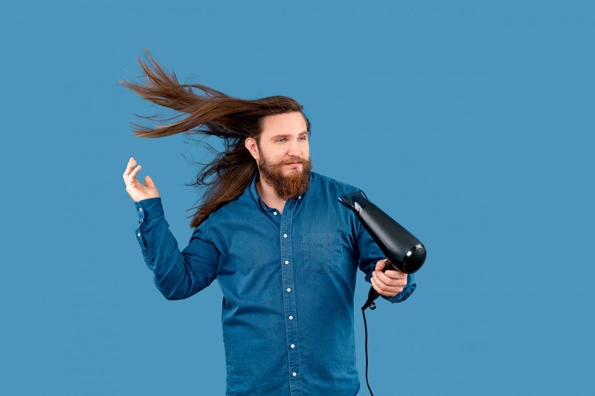 Man with hairdryer in studio.