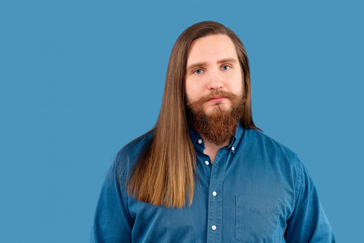 Sad man in studio. Blue background. Sad eyes.